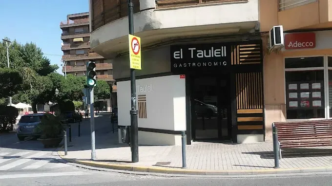 Entrada de El Taulell con el rótulo negro sobre la puerta
