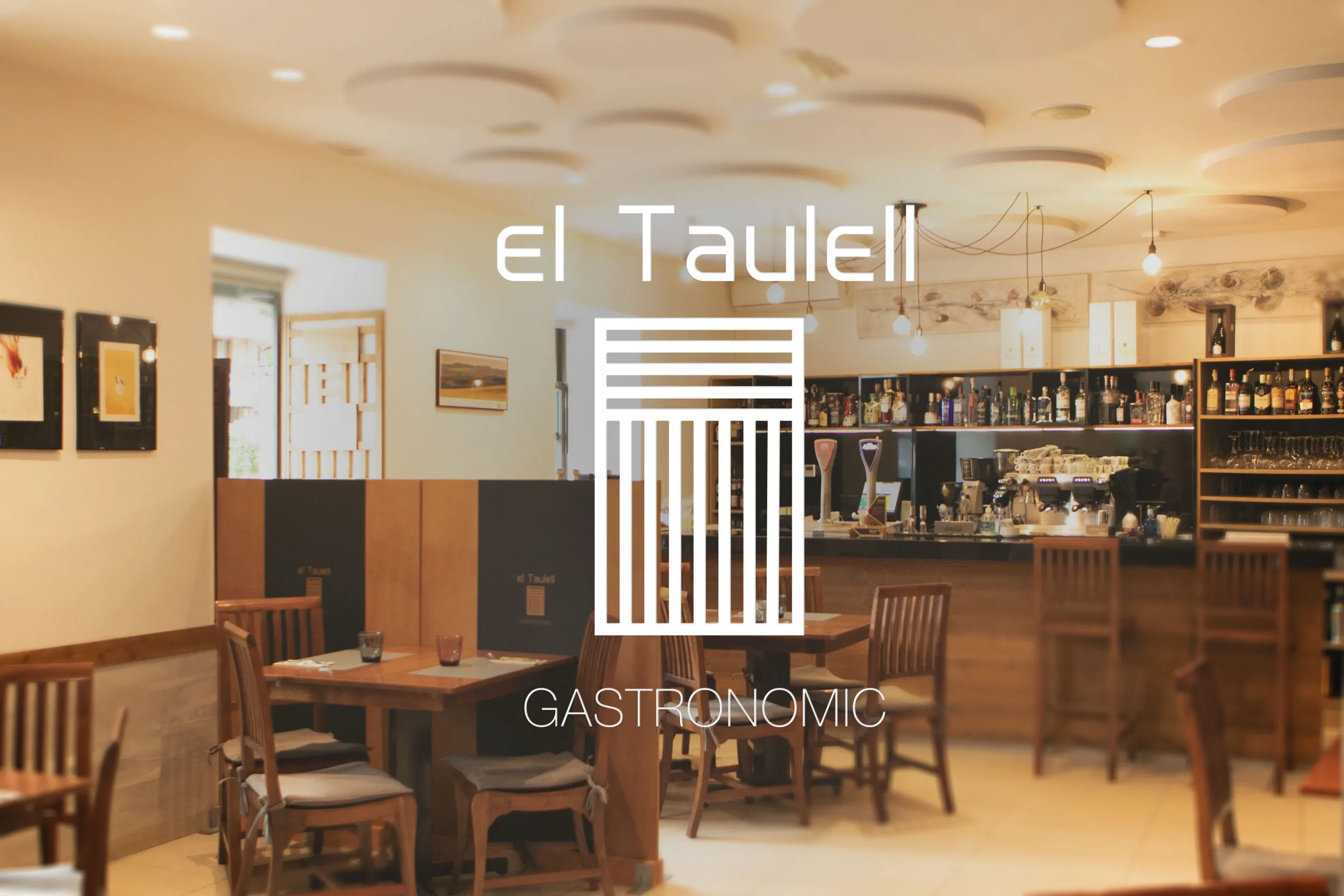 Sala de El Taulell con la barra al fondo y el logotipo de El Taulell Gastronomic