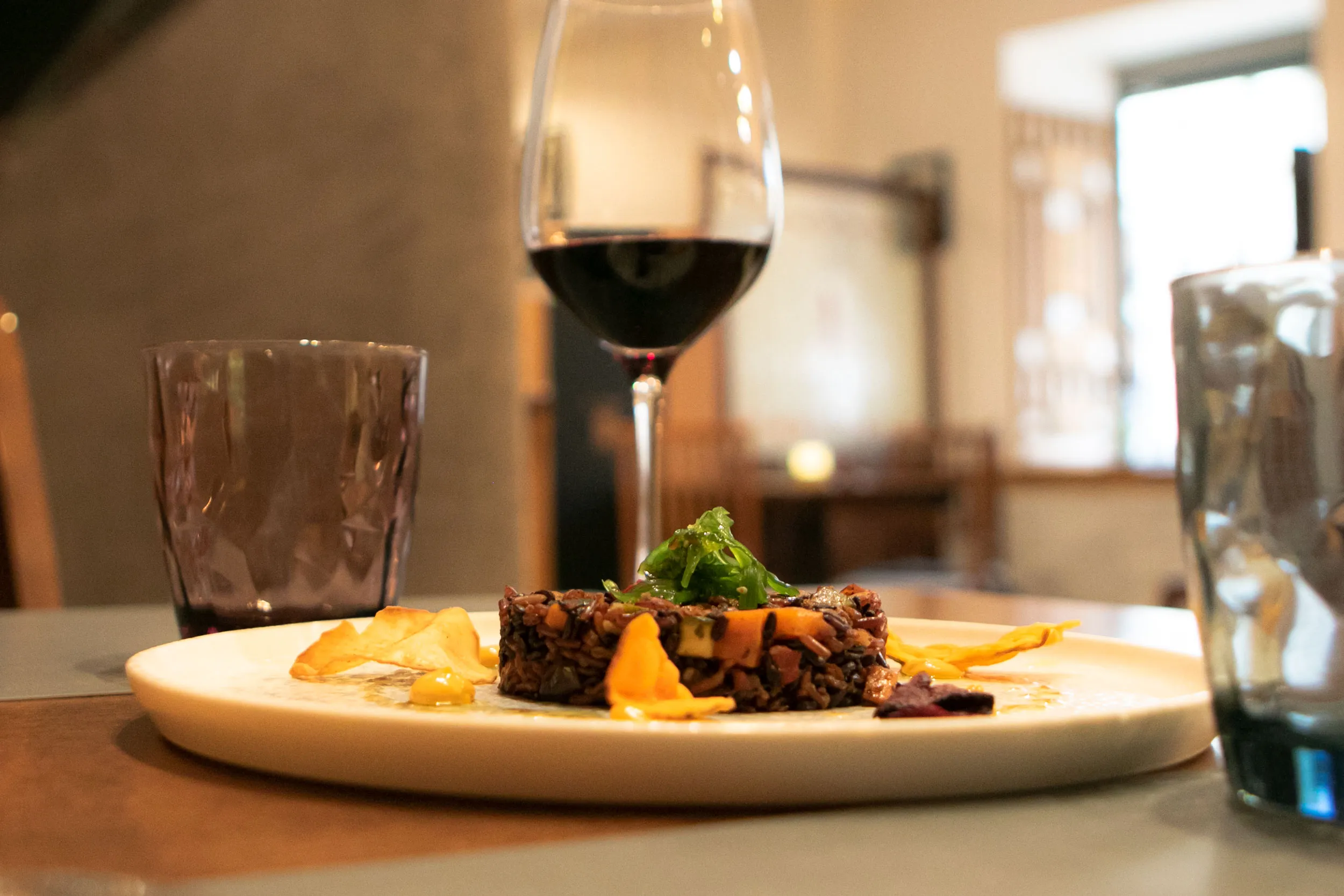 Plato servido junto a una copa de vino tinto